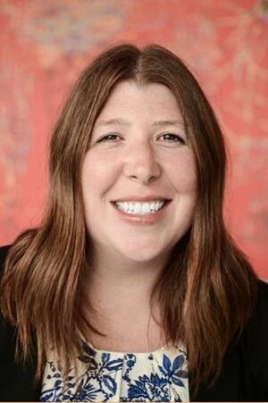 Headshot of Deanna Eckholm, a white woman with long brown hair.